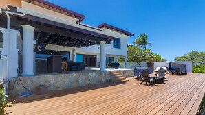 A wooden deck with outdoor seating and a covered area. - Pristine Bay 1005- Villa Loce 4 Bedroom Home (Roatan)