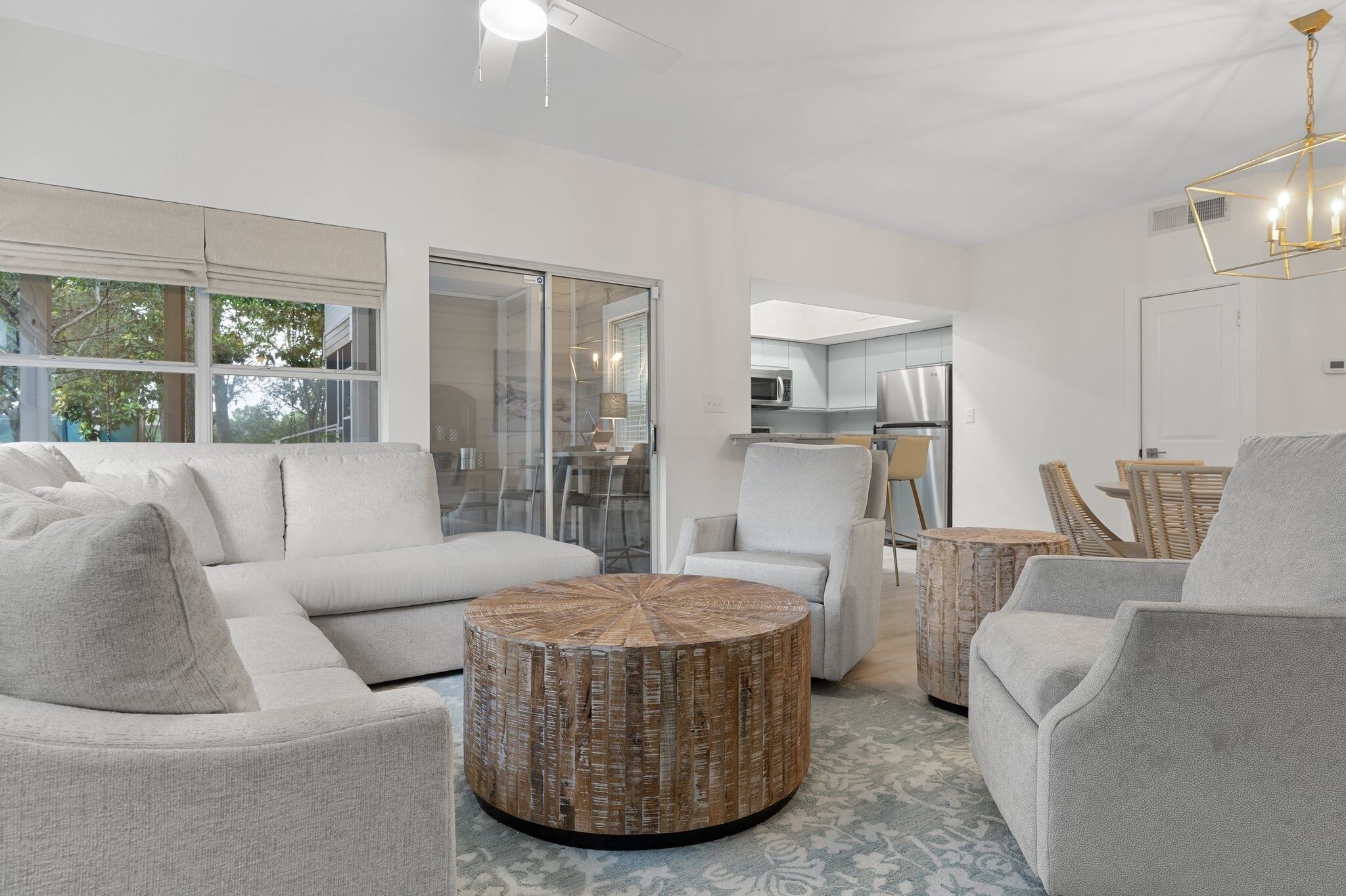 A modern living room with a sectional sofa, round coffee table, and armchairs.