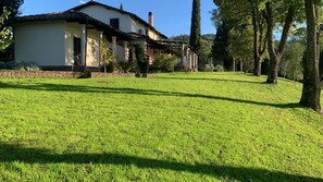A house with a well-maintained lawn, a stone wall, and a clear sky. - Villa il Turchetto, Country House with Pool, 2 km from Terme di Saturnia (Saturnia)