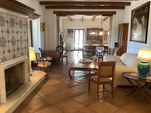 A spacious living room with a fireplace, dining area, and a kitchen in the background. - Villa il Turchetto, Country House with Pool, 2 km from Terme di Saturnia (Saturnia)