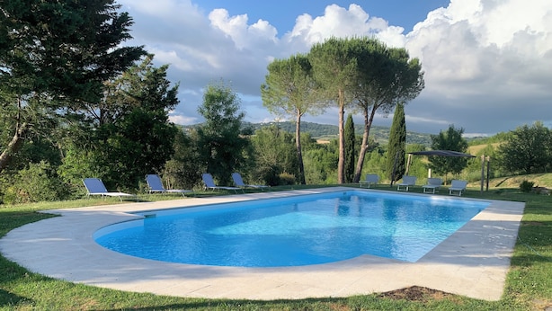 A rectangular swimming pool with a curved edge, surrounded by a concrete deck. - Villa il Turchetto, country house with swimming pool 2km from Terme di Saturnia (Saturnia)