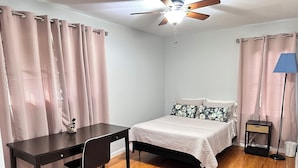 A bedroom with a bed, a desk, a chair, a ceiling fan, and a lamp. - 3-bedroom bungalow in charming Smyrna with WiFi, AC (Smyrna)