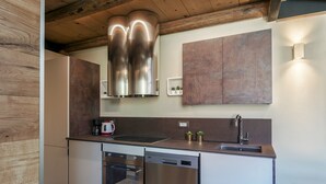 A modern kitchen with stainless steel appliances, wooden cabinets, and a built-in oven.