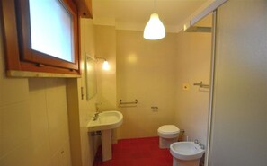 A small bathroom with a sink, toilet, and bidet.