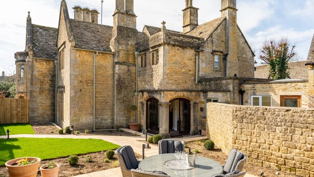 A stone building with a courtyard, outdoor seating, and a well-maintained lawn. - Historic House in Bourton on the Water (Bourton-on-the-Water)