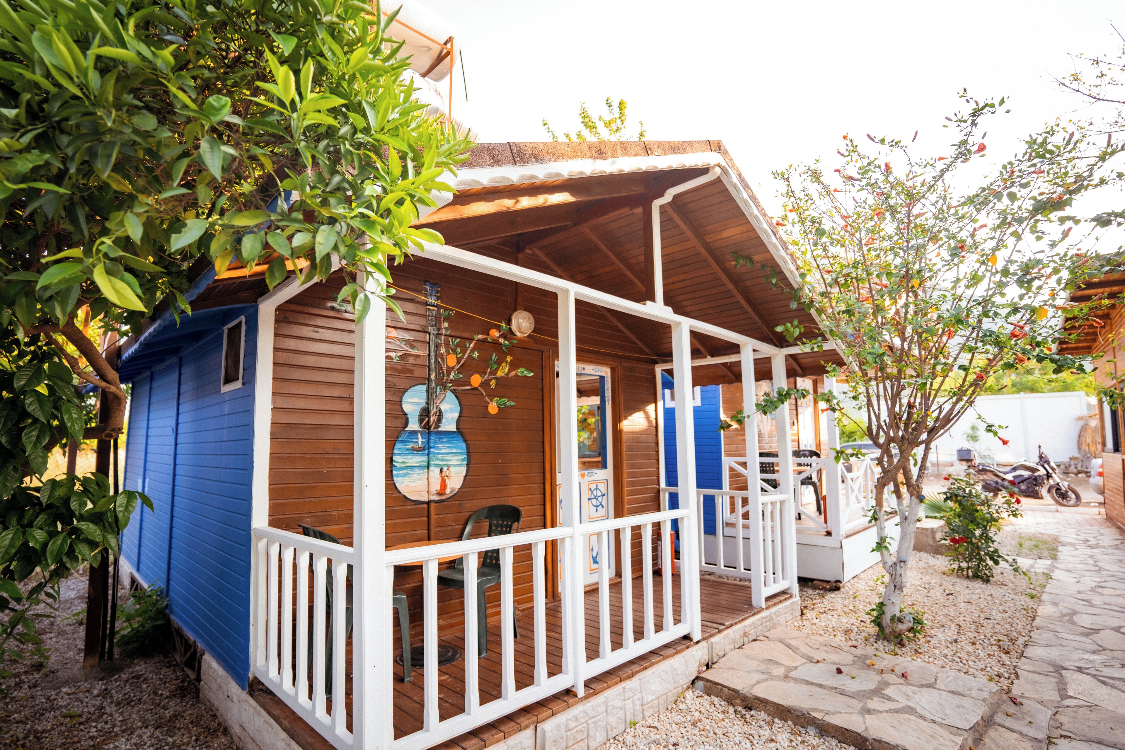 A wooden house with a blue exterior and a porch.