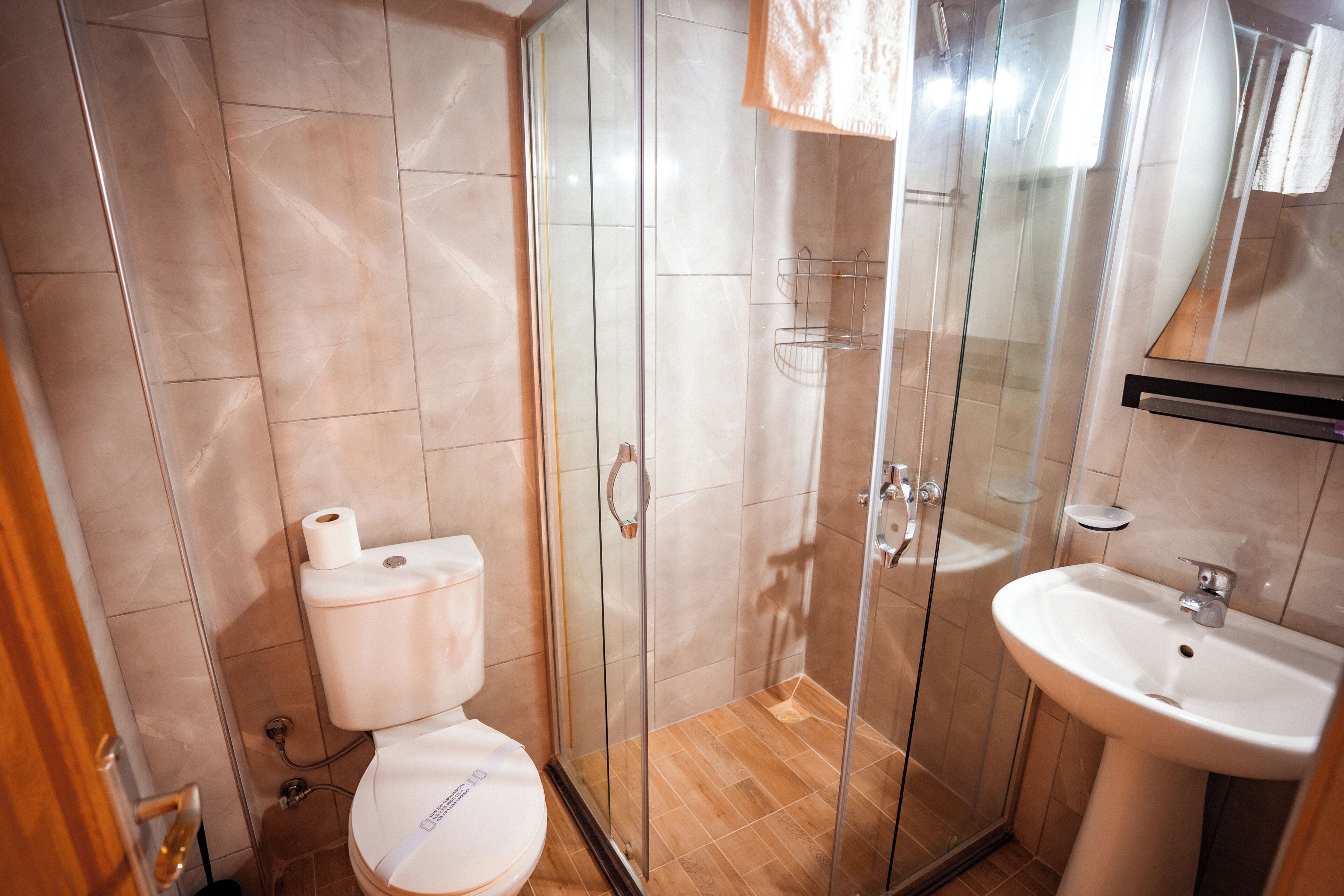 Ein modernes Badezimmer mit Toilette, Duschkabine aus Glas und Waschbecken.