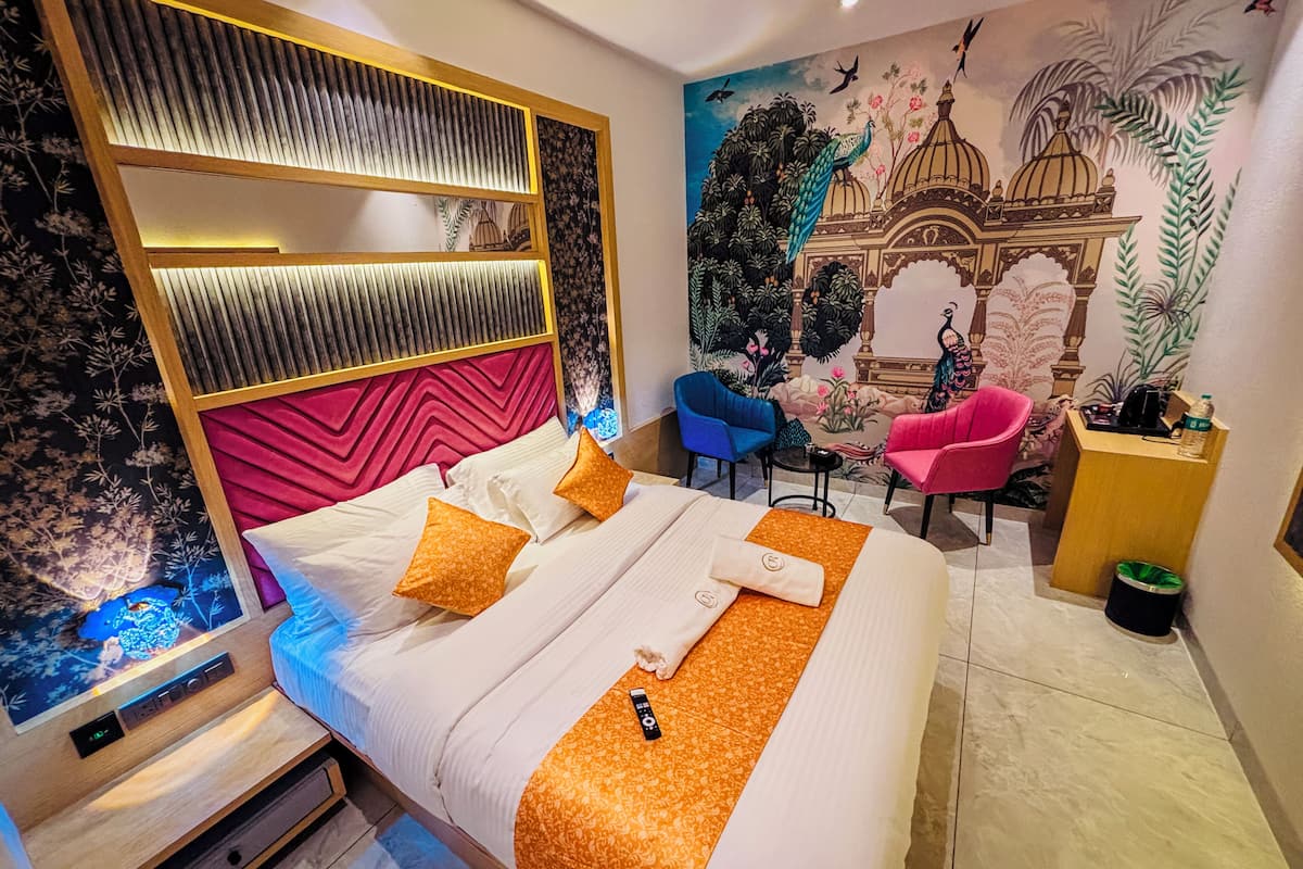 Ein modernes Hotelzimmer mit Bett, Schreibtisch, Stuhl und einer Wandmalerei.