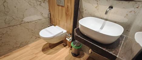 Un baño con inodoro, bidé y lavamanos.