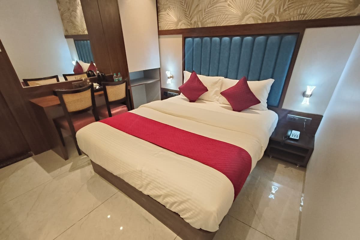 Ein Hotelzimmer mit einem großen Bett, einem Schreibtisch und einem Stuhl.