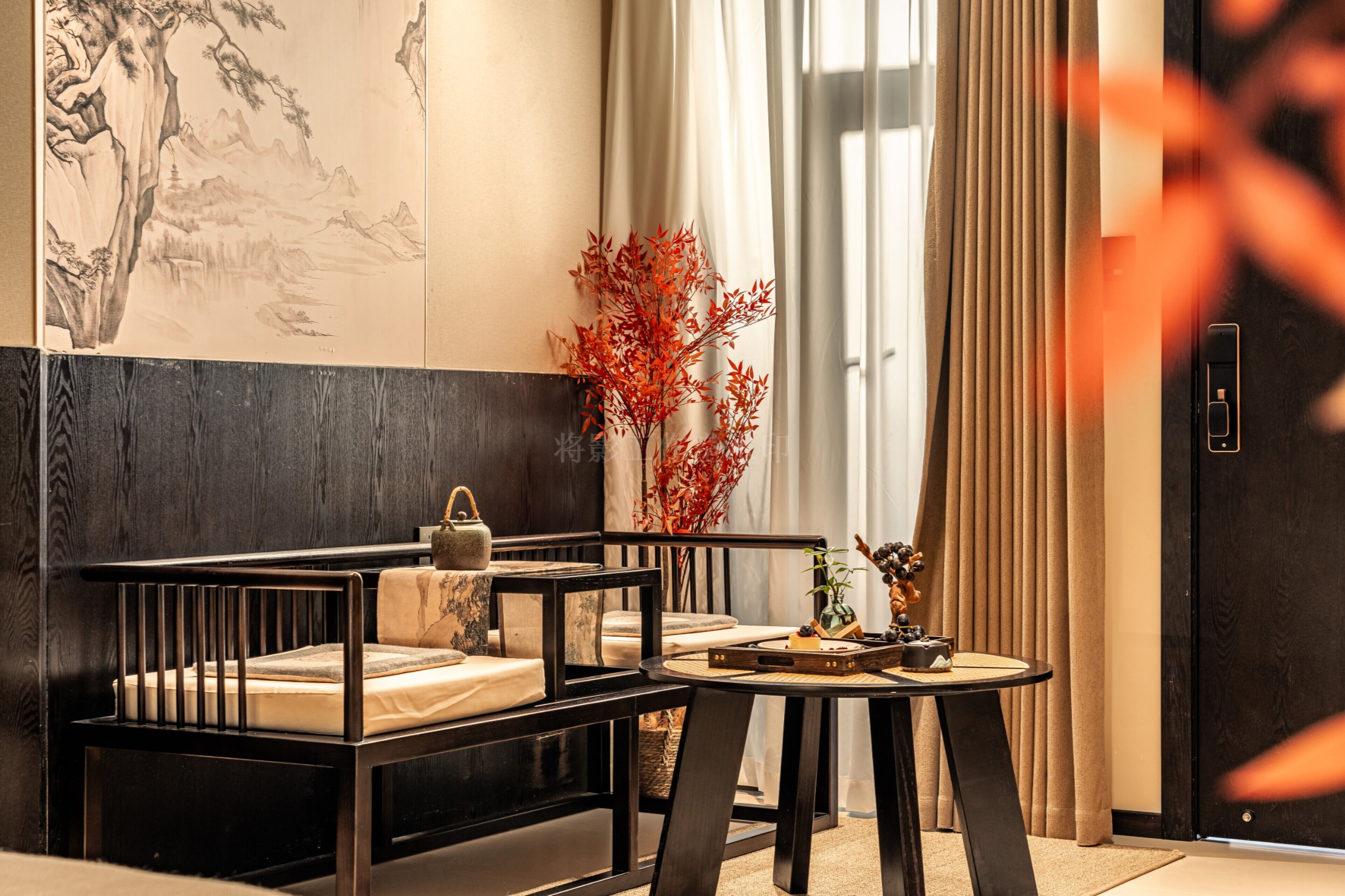 A modern room with a wooden bench, a small round table, and a large window with curtains.