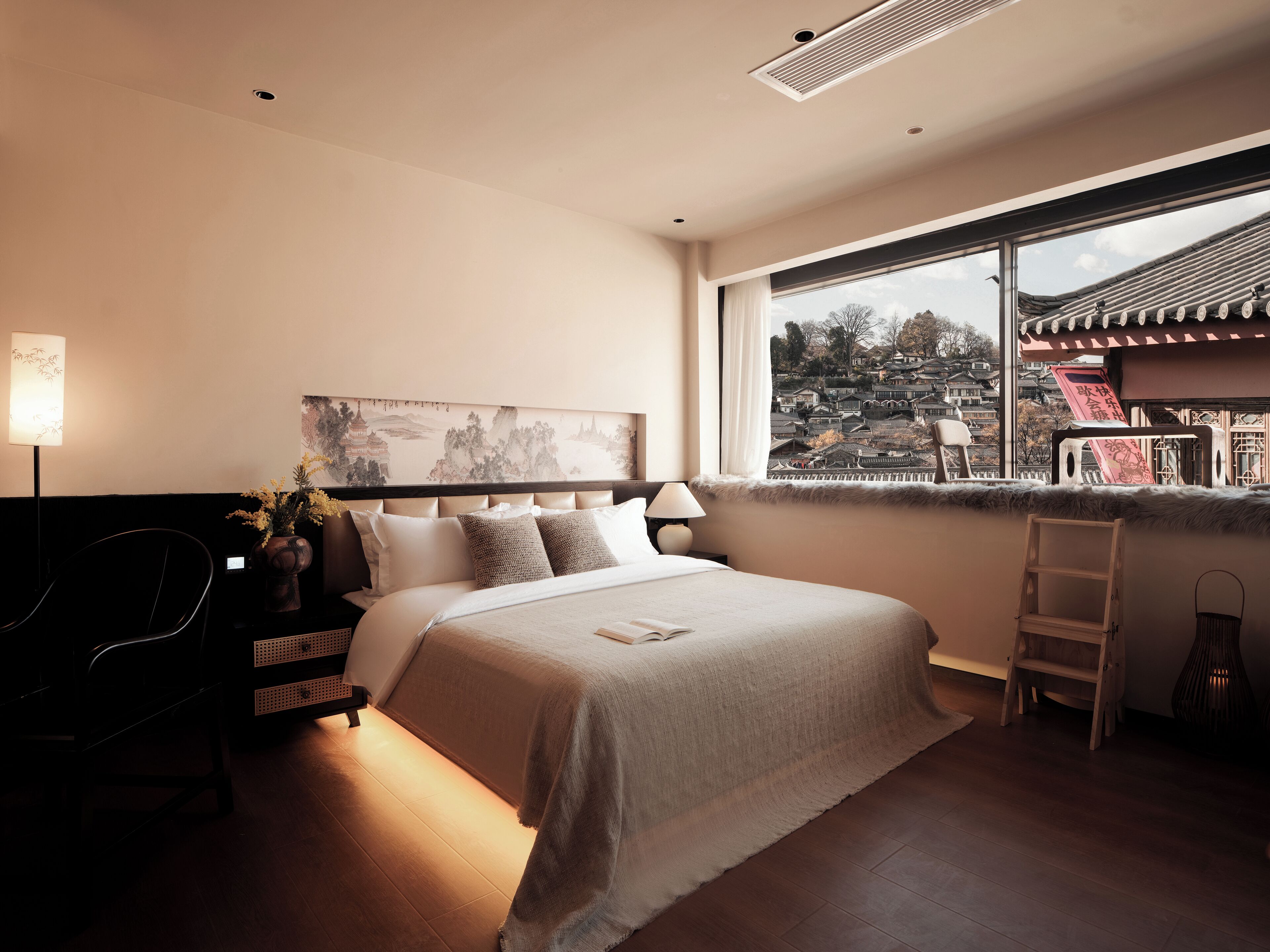 Una habitación de hotel moderna con una cama grande, un escritorio y vistas a la arquitectura tradicional.