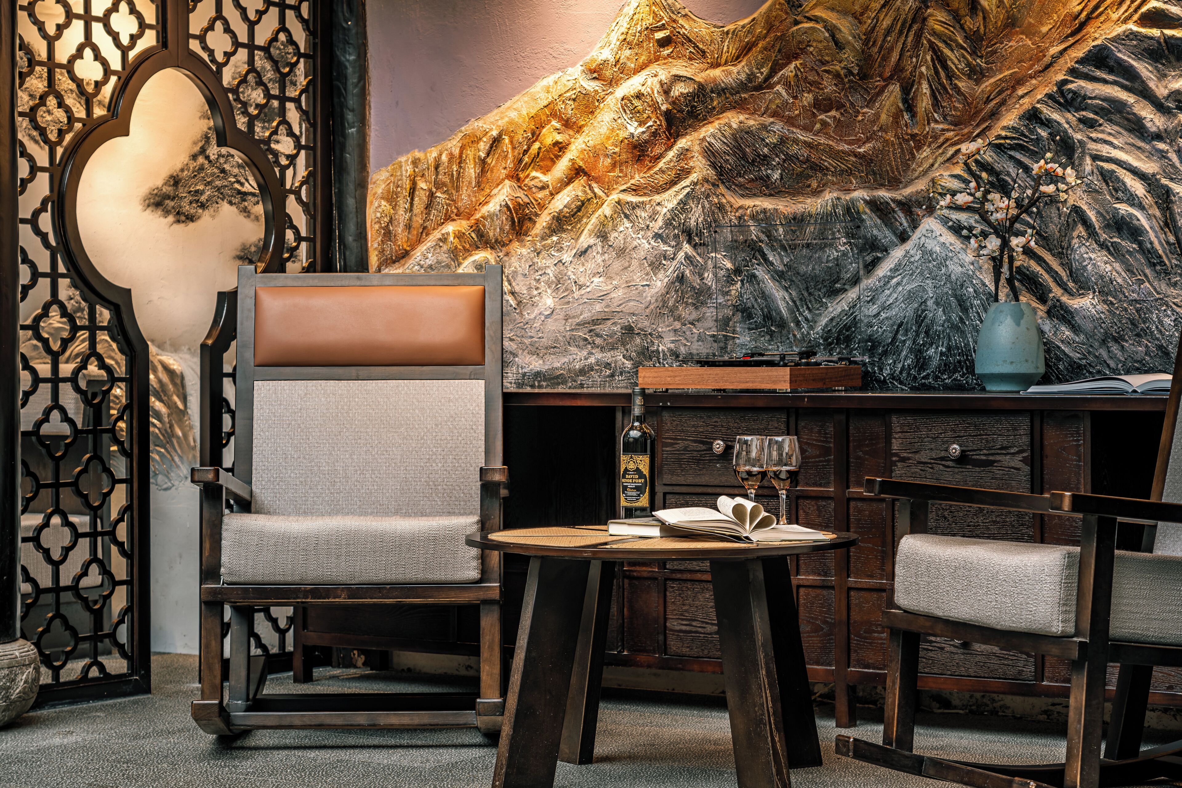 A traditional room with a large mural, a wooden table, and two chairs.