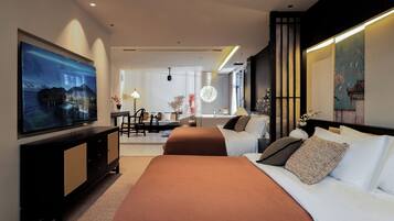 Una habitación de hotel moderna con una cama grande, un escritorio y un televisor montado en la pared.