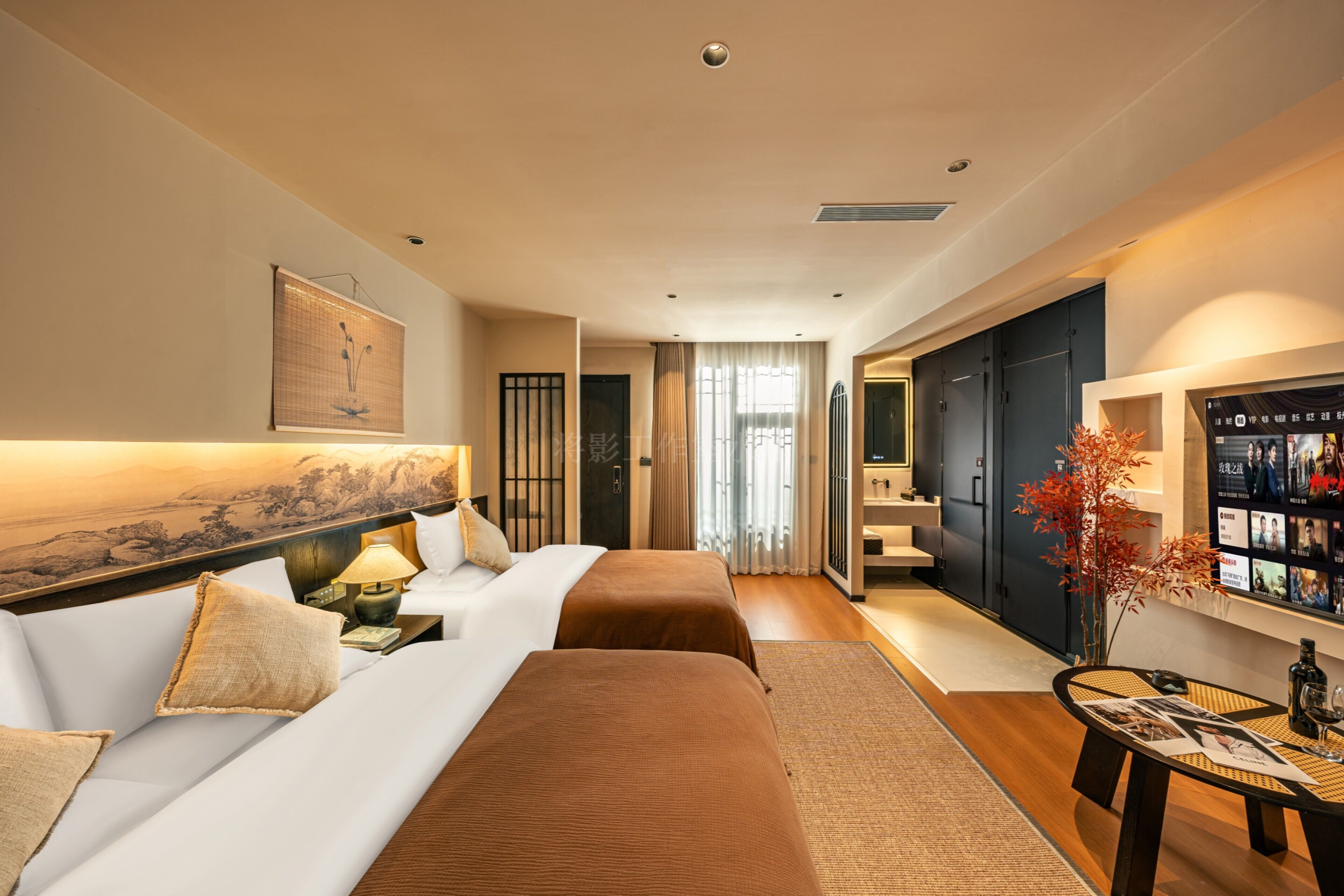 A hotel room with a bed, a sofa, a TV, and a view of the outdoors.