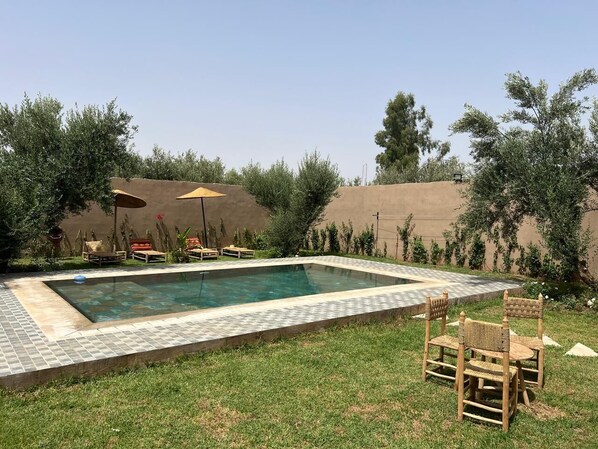 A rectangular swimming pool with a tiled edge, surrounded by a grassy lawn and trees. - Private, unoverlooked villa - For families (Touggana)