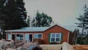 A construction site with a partially built house and large rocks.