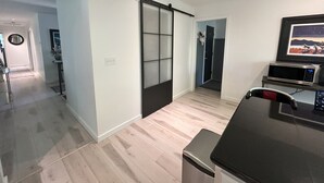 A modern living room with a sliding door, a flat-screen TV, and a microwave. - 4-bedroom house in highly desirable Southside Bozeman with AC and heated garage. (Bozeman)