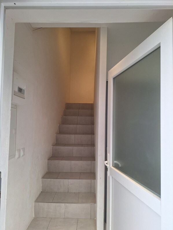 A staircase with beige tiles leading to a landing. - Charming studio with a pool in the heart of Ruoms, Ardèche (Ruoms)