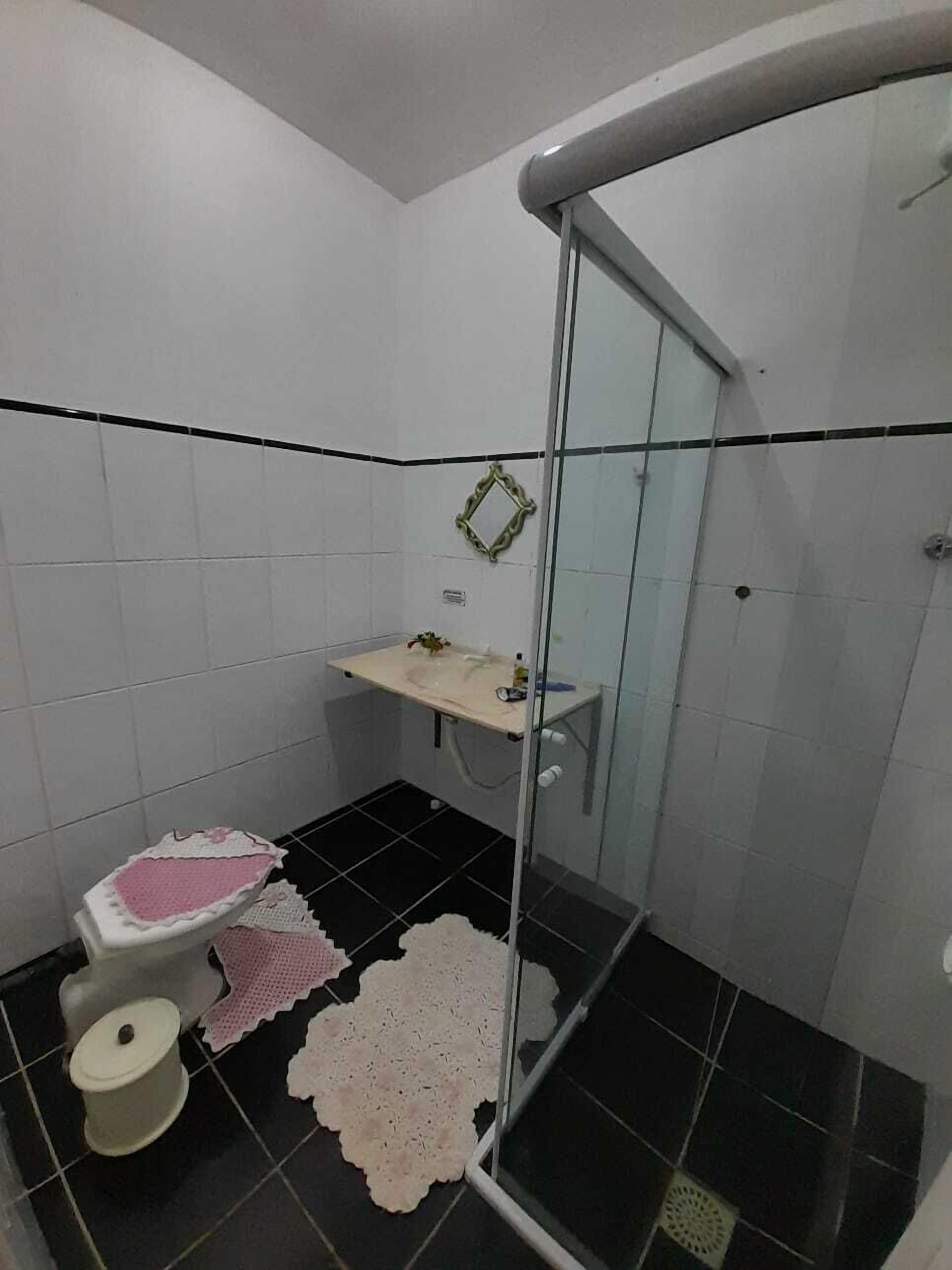 A bathroom with a toilet, sink, and shower area.