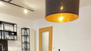 A dining area with a wooden table, green upholstered chairs, and a hanging pendant light. - Sit back and relax with us between the Moselle and the vineyards. (Mehring)
