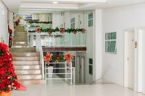 A hotel lobby with a staircase, a reception desk, and a Christmas decoration. - Bombinhas Tourist (Bombinhas)