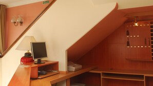 Eine moderne Treppe mit Holzoptik, ein Schreibtisch mit Computer und eine Wandlampe.