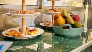 A buffet table with multiple serving platters and a bowl of fruit. - Eco Suite (Treinta y Tres)