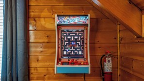 Um console de videogame fixado numa parede de madeira, com um extintor por perto.