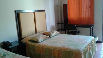 Habitación de hotel con dos camas, un escritorio y una silla.