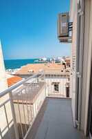 Un balcone con vista sul mare e sugli edifici.