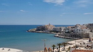 A coastal town with historic buildings, a fortified structure, and a beach area. - my Vesta Suites (Vieste)