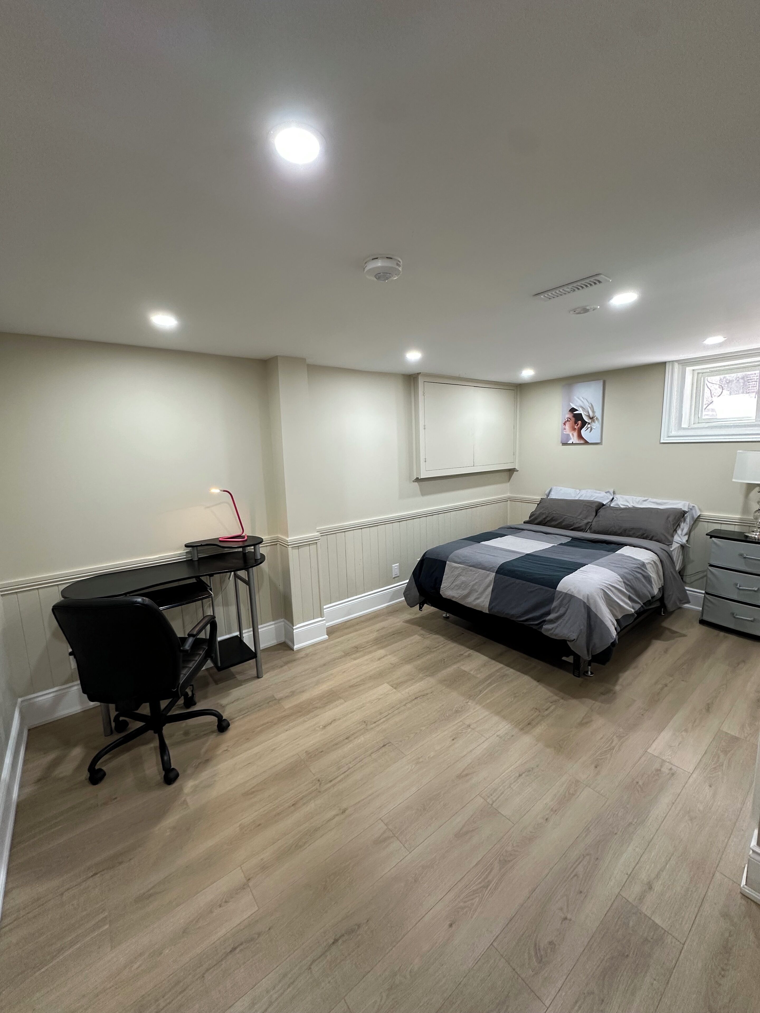 Une chambre à coucher avec un lit, un bureau, une chaise et une fenêtre.