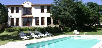 A two-story building with a swimming pool and sun loungers.