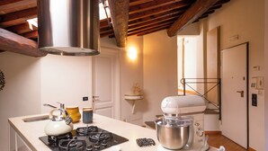 A kitchen with a gas stove, kettle, mixer, and wooden countertop. - Elegant apartment with panoramic terrace in the historic heart of Pistoia (Pistoia)