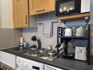 A kitchen with a stove, microwave, and various appliances.