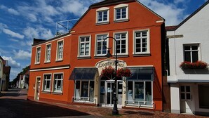 Ein rotes Gebäude mit einem Schild, auf dem "Bogenhaus" steht, und ein weißes Gebäude daneben.