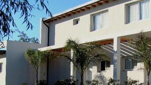 A modern building with multiple balconies, each with a wooden pergola. - Colon Village (Colon)