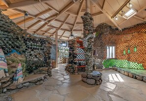 Um interior rústico com paredes de pedra, teto de madeira e chão em pedra.