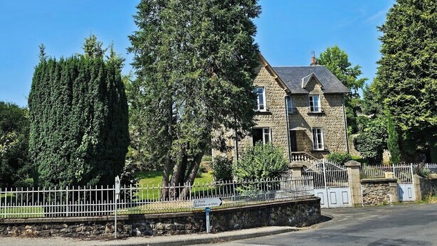 A stone building with a stone facade, a stone staircase, and a white metal fence. - Pretty house with garden in the heart of a Corrèze village (Chamberet)