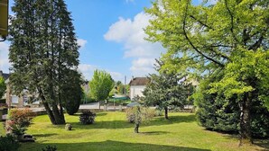 A well-maintained garden with various trees and shrubs, a lawn, and a pathway. - Pretty house with garden in the heart of a Corrèze village (Chamberet)