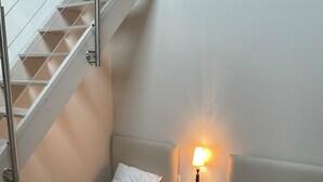 A bedroom with two single beds, a nightstand with a lamp, and a staircase. - Pretty house with garden in the heart of a Corrèze village (Chamberet)