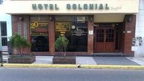 The exterior of Hotel Colonial with a '20th Anniversary' sign, a brick facade, and a gated entrance. - Hotel Colonial (Buenos Aires)