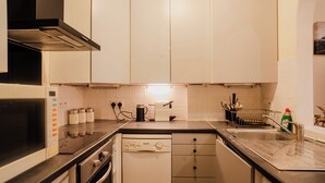 Una cocina moderna con armarios blancos, lavavajillas, microondas y estufa.