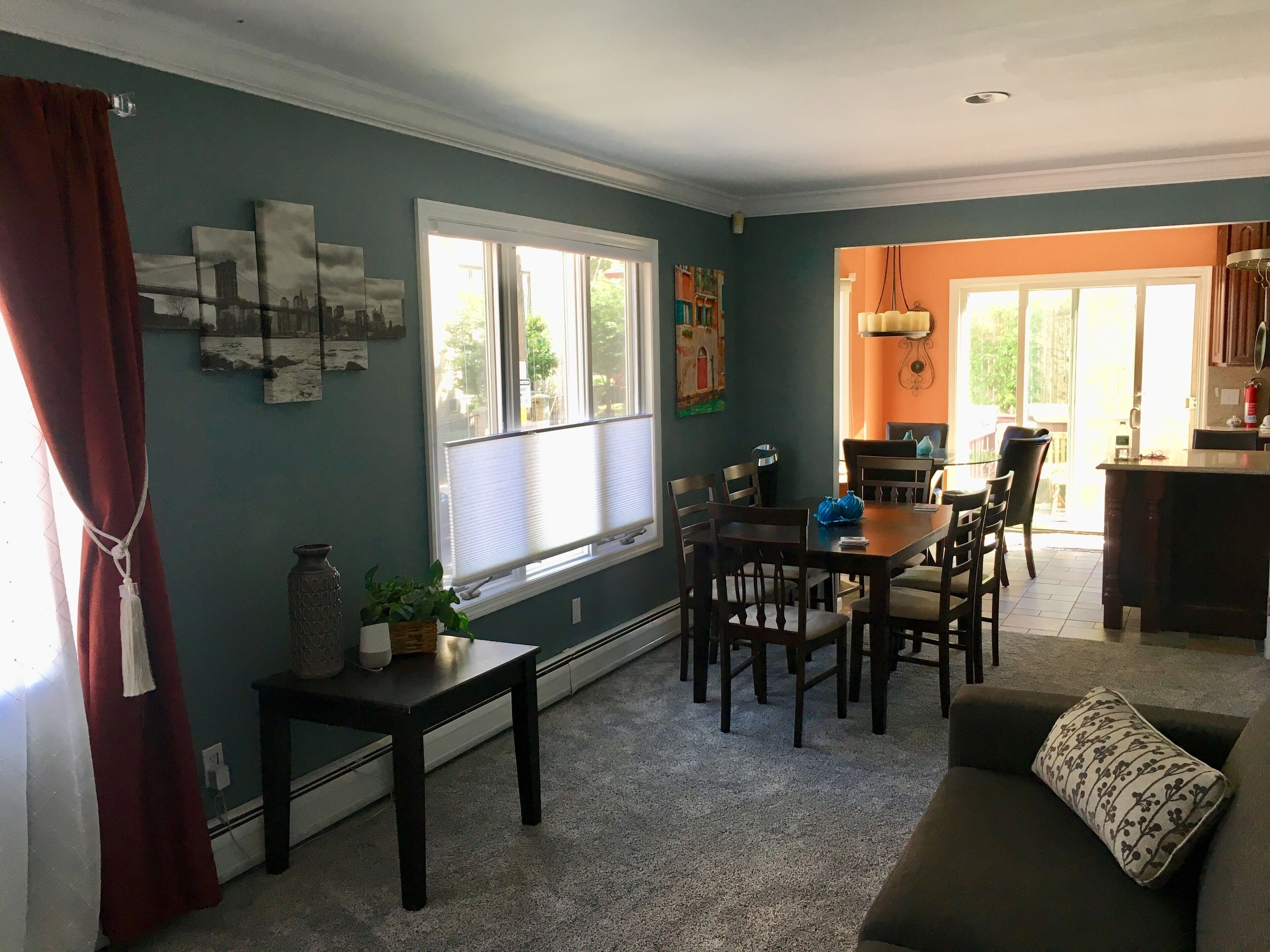 A dining area with a table and chairs, a sofa, and a kitchen area visible through an open door.