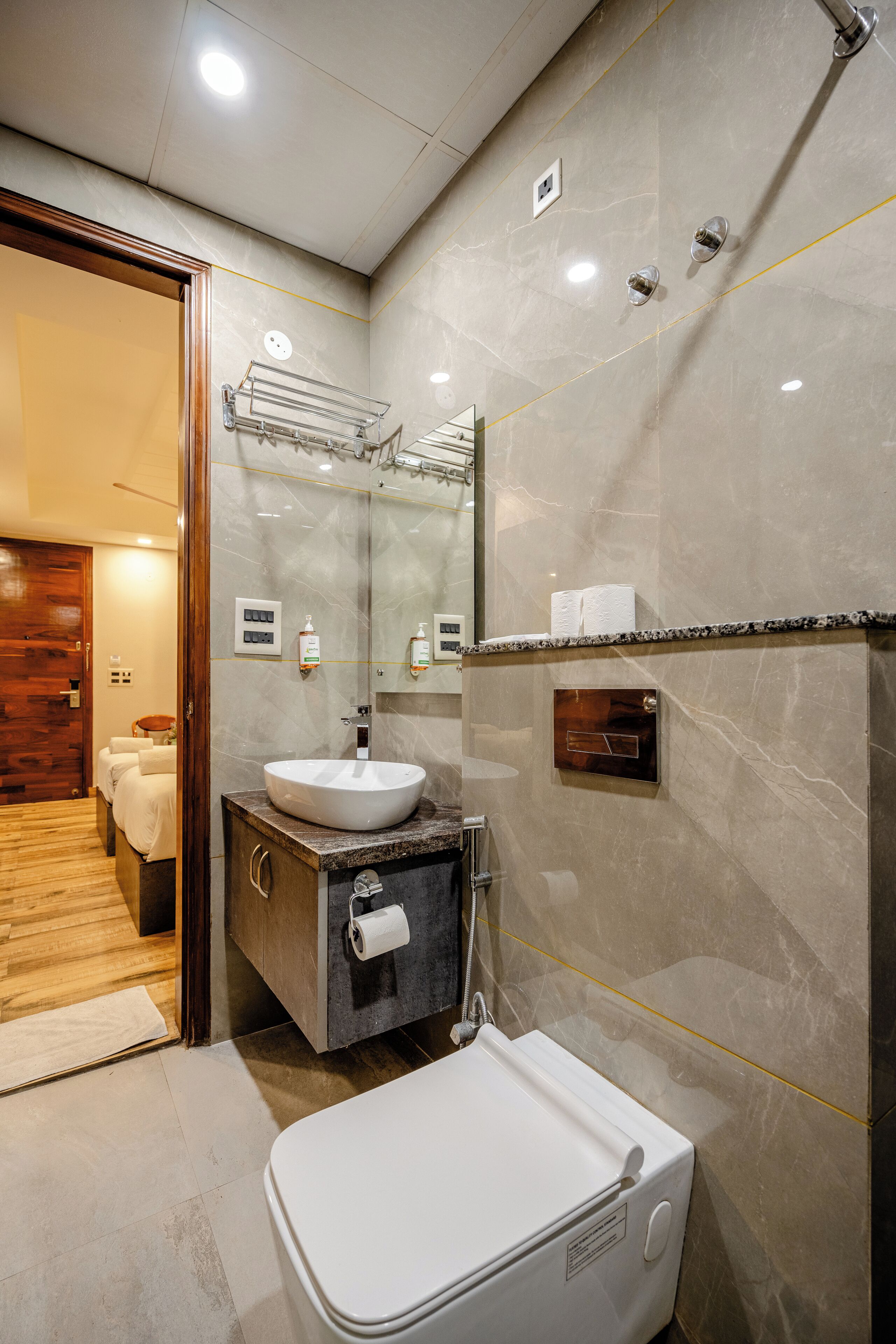 A modern bathroom with a white sink, a mirror, and a toilet.