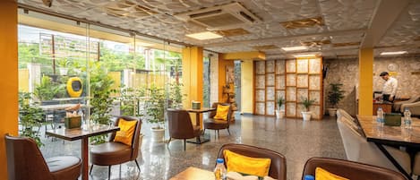 A modern hotel lobby with a geometric ceiling, comfortable seating, and a view of the outdoors.