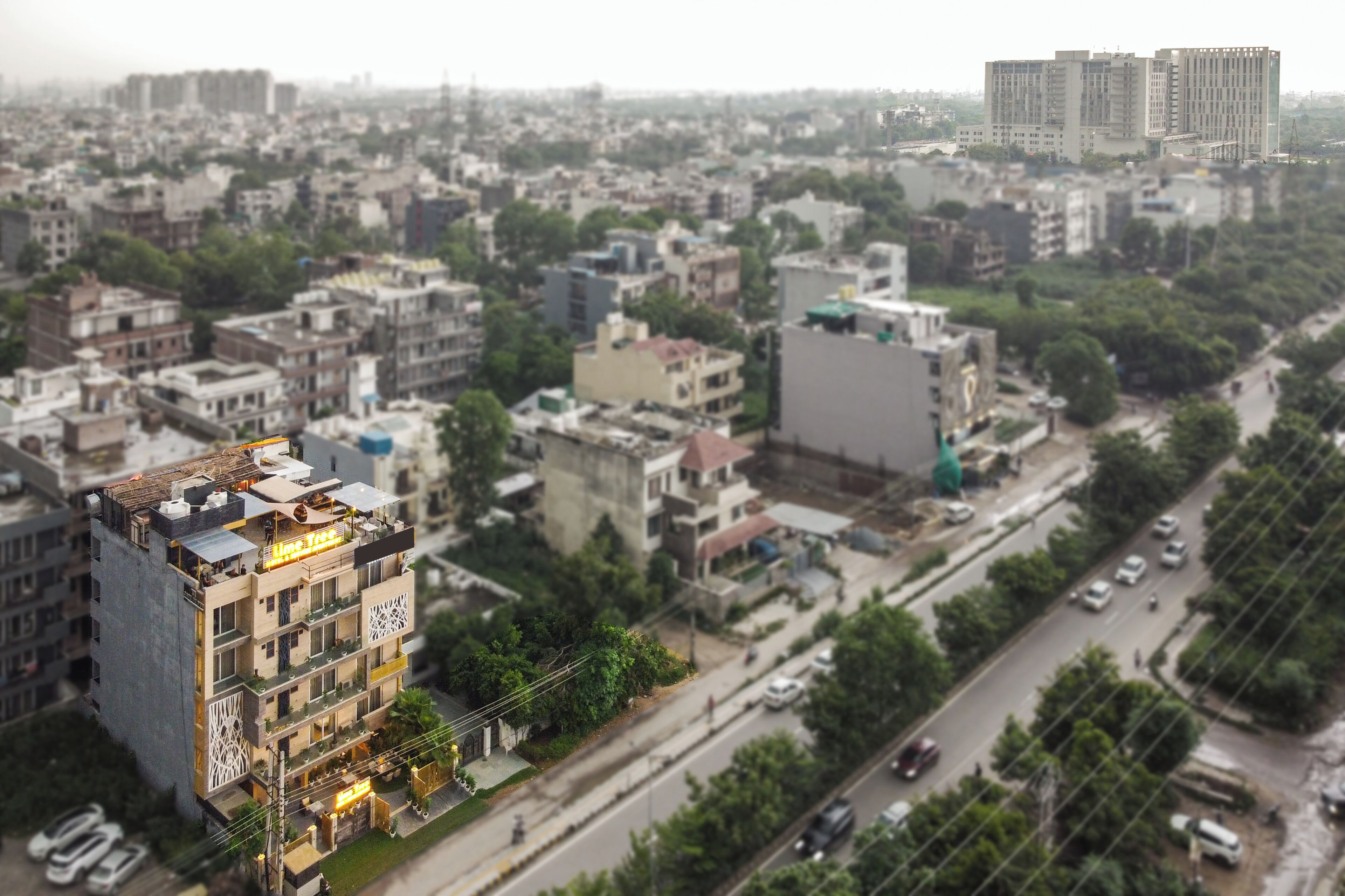 Vista aérea de una zona urbana densamente poblada con diversos edificios de varios pisos, calles y áreas verdes.
