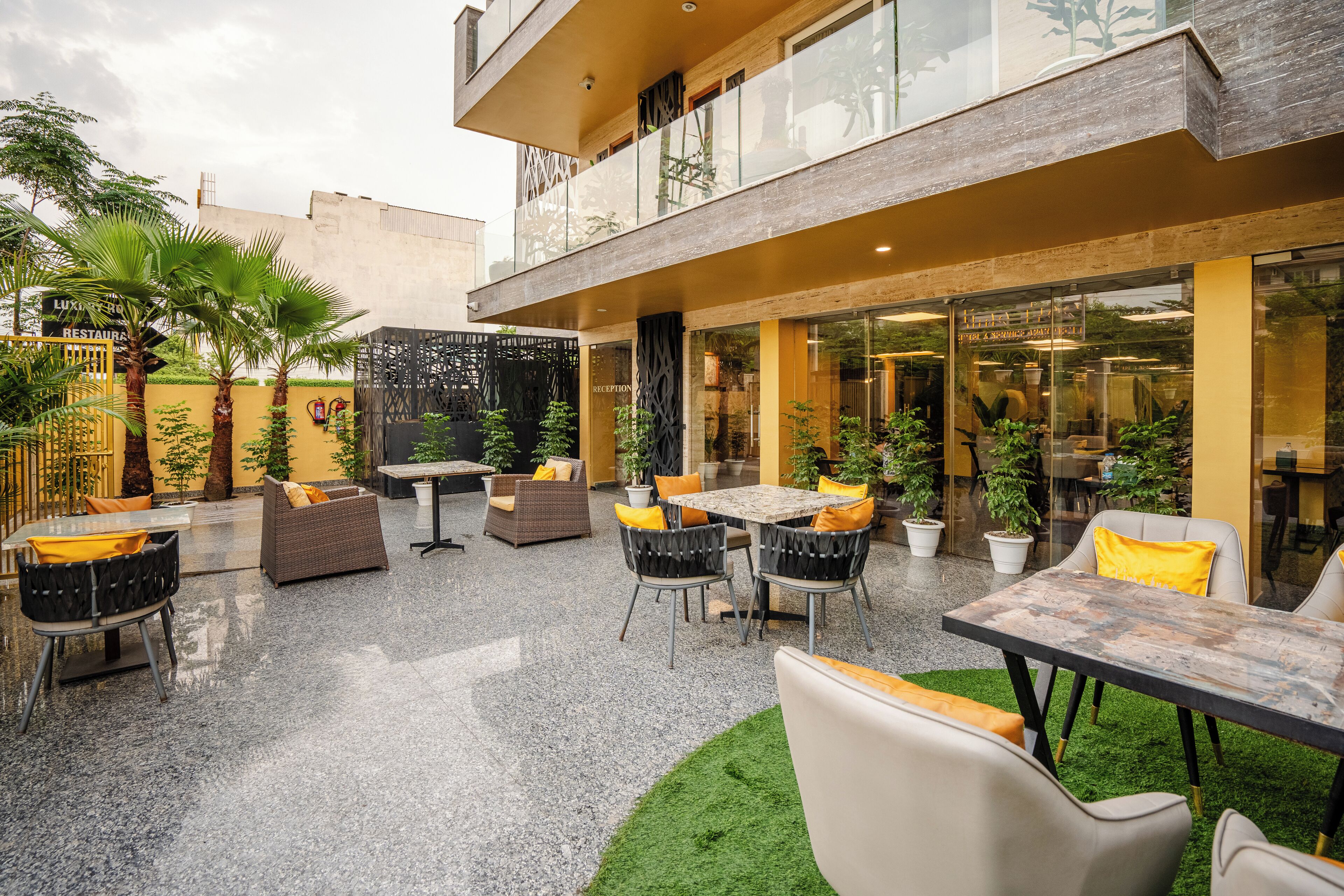 An outdoor patio area with seating arrangements and a reception desk.