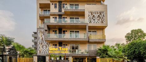 Un hotel de varios pisos con un letrero que dice "Lime Tree Hotel & Service Apartment".